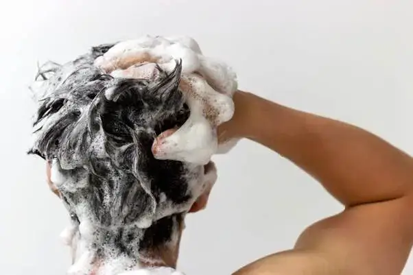 Caffeine shampoo bottle held under running water
